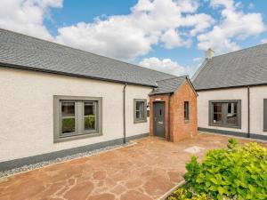 an external view of a house with a courtyard at Westertonhill Holiday Lodges - Hot Tub Hire Available in Balloch