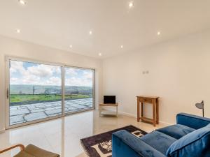 uma sala de estar com um sofá azul e uma grande janela em Hen House View 2 - Uk41551 em Crawshaw Booth