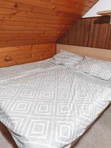 a large bed in a room with wooden walls at Apartment HM in Gozd Martuljek
