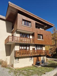 a house with a wooden balcony on the side of it at Boost Your Immo Le Gaubert Vars 805 in Vars