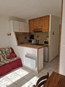 a small kitchen with a couch and a microwave at Boost Your Immo Le Gaubert Vars 805 in Vars