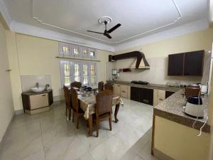 a kitchen with a table and chairs in a room at The Choudhury Manor Homestay in Guwahati