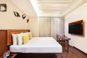 um quarto de hotel com uma cama e uma cadeira em Keys Select by Lemon Tree Hotels, Gandhi Ashram, Ahmedabad em Ahmedabad