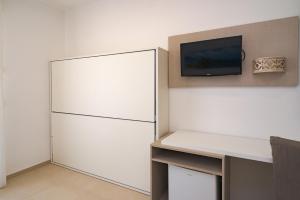 Zimmer mit einem weißen Kühlschrank und einem TV in der Unterkunft Hotel Jonio in Noto Marina