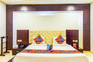 1 dormitorio con 1 cama grande y cabecero grande en FabHotel Transit Delhi Airport Mahipalpur, en Nueva Delhi