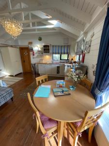 a kitchen and dining room with a wooden table and chairs at Sailaway perfect romantic break in Norwich