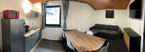 eine kleine Küche mit einem Holztisch und einem Sofa in der Unterkunft Landhaus Marlies Apartments in Zell am See