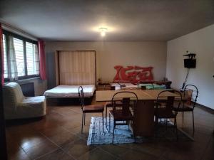 uma sala de estar com uma mesa e uma cama em Soggiorno Via del golf 41 em Carimate