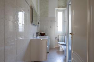 ラ・スペツィアにあるLa Spezia Holidaysの白いバスルーム(洗面台、トイレ付)