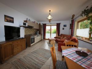 a kitchen and living room with a couch and a table at Ferienwohnung Bärnbachl in Bayerisch Eisenstein +20 photos