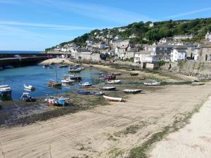 a group of boats sitting on the shore of a harbor at Modern 2 Bed Apt Centre Of Penzance, Lift Access in Penzance