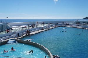 una piscina en una playa con gente en el agua en Modern 2 Bed Apt Centre Of Penzance, Lift Access, en Penzance