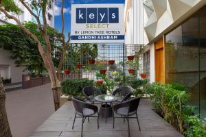 a patio with a table and chairs in front of a building at Keys Select by Lemon Tree Hotels, Gandhi Ashram, Ahmedabad in Ahmedabad