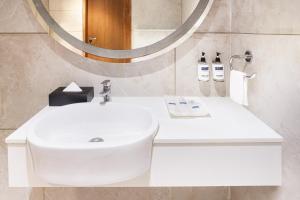 a bathroom with a white sink and a mirror at Keys Select by Lemon Tree Hotels, Gandhi Ashram, Ahmedabad in Ahmedabad