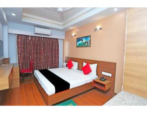 a hotel room with a bed with red pillows at Hotel SPS Inn, Rewa in Rewa