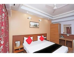 a bedroom with a bed with red pillows at Hotel SPS Inn, Rewa in Rewa