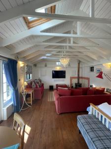 a living room with red couches and a tv at Sailaway perfect romantic break in Norwich