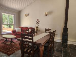 een eetkamer met een tafel en een houtkachel bij St Aidan's Manor in Grahamstown