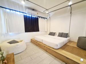 1 dormitorio con 2 camas y ventana en The Companion en Bangkok