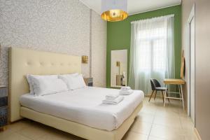 a bedroom with a white bed and a green wall at Italianway - Cannobio 8 in Milan