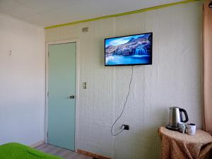 a television hanging on a wall with a room at Habitación Chilota in Castro +2 photos