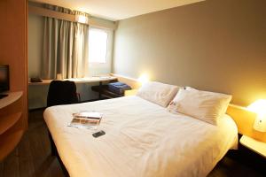 A bed or beds in a room at Ibis Auray