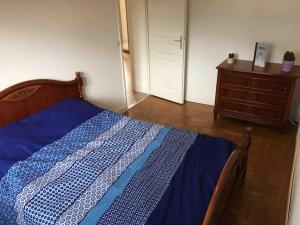 een slaapkamer met een blauw bed en een dressoir bij Appartement 55m2 en beaujolais & ENEDIS à 15 min in Saint-Germain-Nuelles