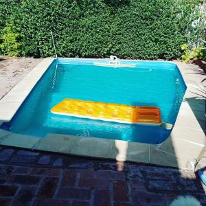 una piscina con un banco en el medio en Habitación en casa con pileta en Río Ceballos en Río Ceballos
