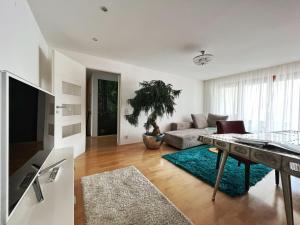 a living room with a couch and a table at Hotel Hellers Twenty Four II -24h-Check-In- in Friedrichshafen