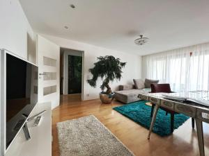 ein Wohnzimmer mit einem Sofa und einem Tisch in der Unterkunft Hotel Hellers Twenty Four II -24h-Check-In- in Friedrichshafen