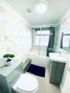 a bathroom with a toilet and a sink and a tub at HU-Thirteen Apt Two- Sleeps 4 in Hessle