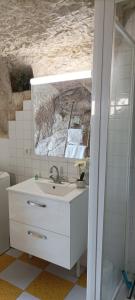 a bathroom with a sink and a mirror at Gite des Perreyeurs - maison troglodyte avec vue sur Loire in Montsoreau