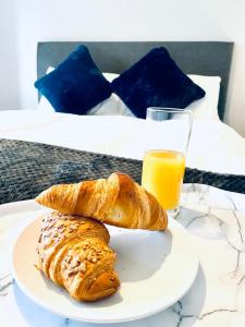 two croissants on a plate next to a glass of orange juice at HU-Thirteen Apt Two- Sleeps 4 in Hessle