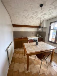 a kitchen with a wooden table in a room at Sous l'Alpette en Chartreuse in Saint-Pierre-dʼEntremont