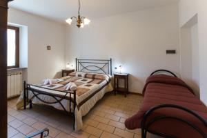 グッビオにあるAgriturismo Casella Del Pianoのベッドルーム(ベッド1台、ソファ付)