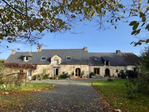 a large stone house with a driveway at La Ville de Mainguy in Josselin