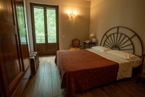 um quarto com uma cama grande e uma janela em La Finestra sul Po - Agriturismo em Monticelli dʼOngina