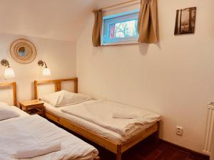 2 camas individuais num quarto com uma janela em Chalupa Zdíkov na Šumavě em Zdíkov