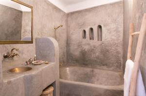 a bathroom with a sink and a bath tub at RIAD MAJWRIL in Marrakesh