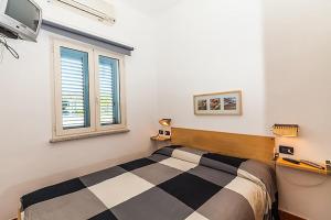 a bedroom with a bed and a window at Le Residenze Blu Sardinia in La Caletta