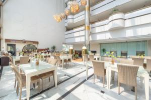 a rendering of a restaurant with tables and chairs at Lux Tychi Hotel in Malang