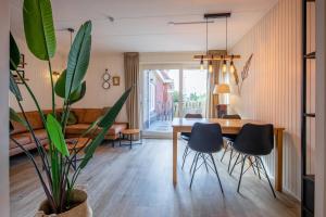 a dining room with a table and a potted plant at De Leeuwerik in De Koog