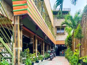 een straat voor een gebouw met planten bij OYO 2518 Wilma Hotel Ii Premier in Kupang