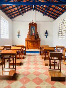 a church with wooden tables and a clock in a room at Pousada Chalés da Lua in Munhoz