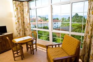 Aparthotel Cabicastro في بورتونوفو: غرفة مع طاولة وكراسي ونافذة كبيرة