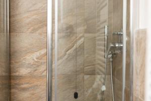 een douche met een glazen deur in de badkamer bij BAITA NOEMI in Livigno