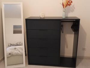a black dresser in a bedroom with a mirror at Le Blason du Poête in Mayet