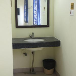 a bathroom with a sink and a mirror at Geetha Residency in Kanchipuram