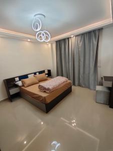 - une chambre avec un lit et un lustre dans l'établissement Rivera Sharm Habiba Apartments, à Charm el-Cheikh