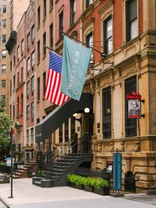 two flags are hanging in front of a building at The William powered by Sonder in New York